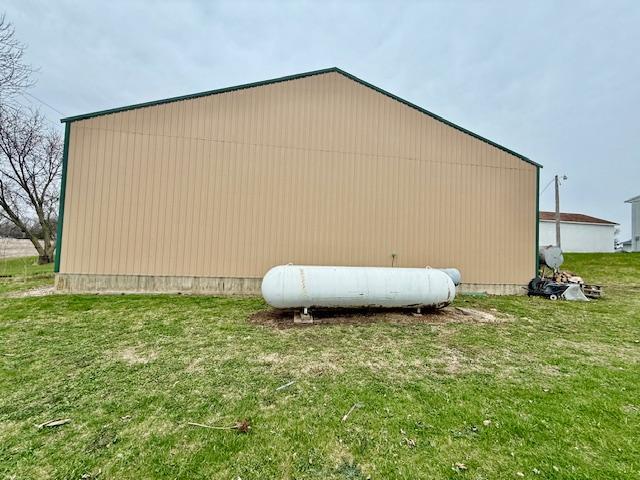 view of side of property featuring an outbuilding and a lawn