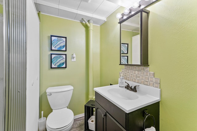 bathroom featuring ornamental molding, toilet, tasteful backsplash, and vanity