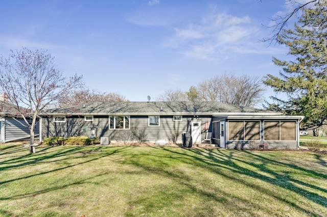 back of property featuring a sunroom and a lawn