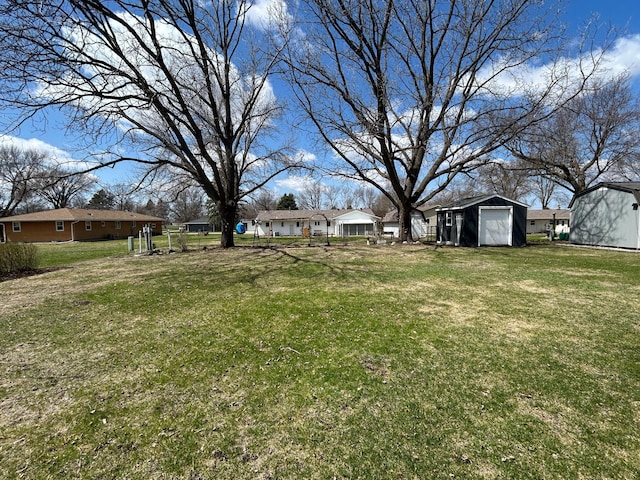 view of yard featuring an outdoor structure, a residential view, and a storage shed