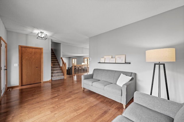 living room featuring wood finished floors and stairway