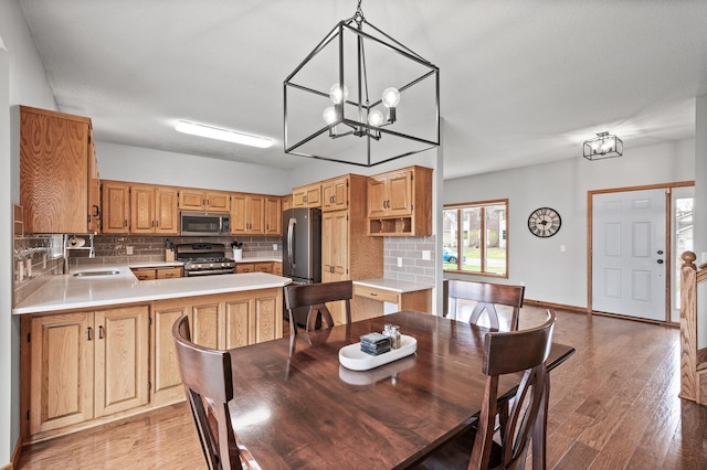dining area with baseboards, light wood finished floors, and a chandelier