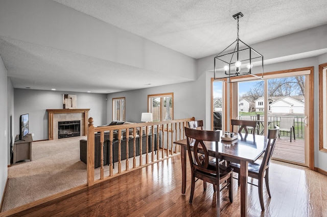 dining room featuring an inviting chandelier, a textured ceiling, and wood finished floors