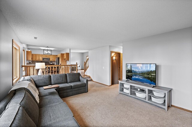 living area with stairway, baseboards, light carpet, and a textured ceiling