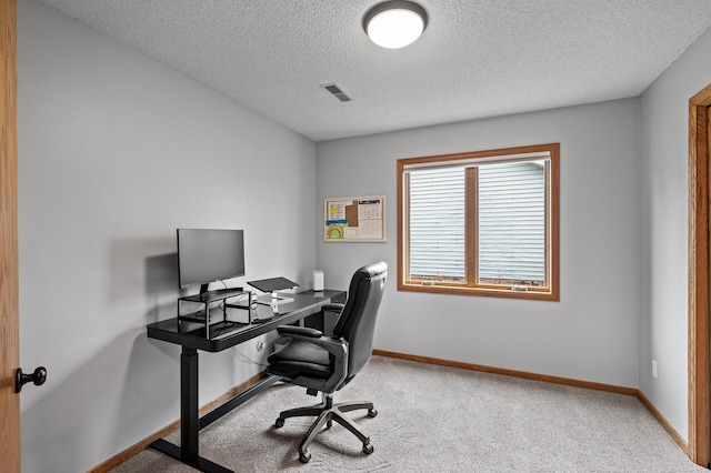 office area with a textured ceiling, visible vents, light carpet, and baseboards