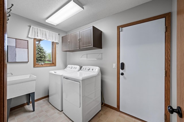 clothes washing area featuring cabinet space, baseboards, washing machine and dryer, and light floors