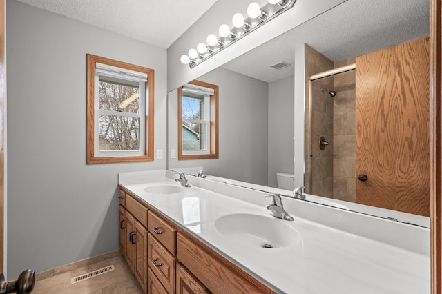 full bath featuring visible vents, a sink, double vanity, and toilet