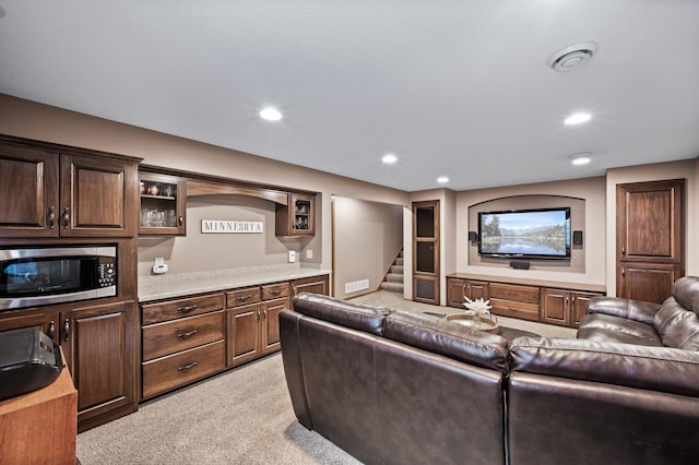 living area featuring light colored carpet, recessed lighting, stairs, and visible vents