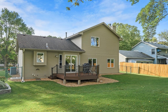 back of property with a lawn, a fenced backyard, a wooden deck, and a chimney