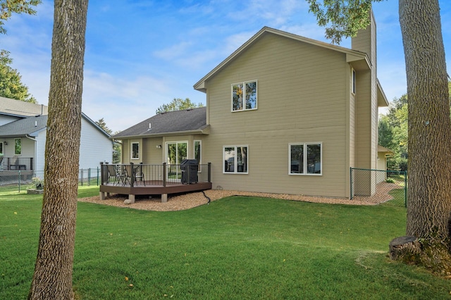 back of house with a lawn, fence, a chimney, and a wooden deck