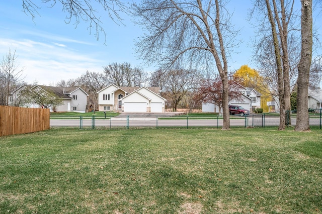 view of yard with a garage, fence, and a residential view