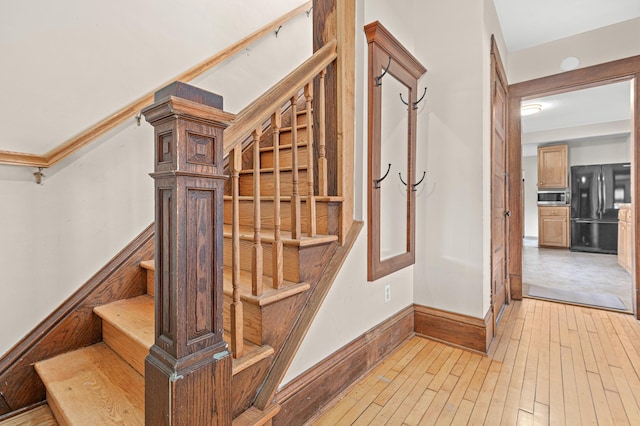 stairway with baseboards and hardwood / wood-style floors