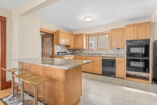 kitchen featuring a kitchen breakfast bar, tasteful backsplash, light stone counters, black appliances, and a peninsula