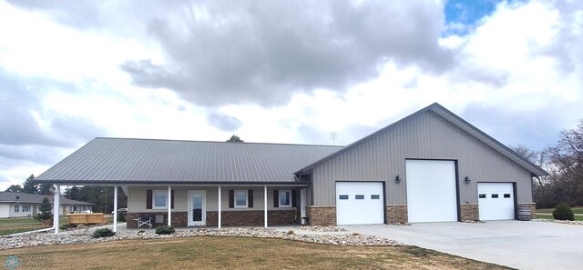 409 Prairieview St, St Thomas, ND 58276 - view of front of house with covered porch, driveway, stone siding, a front yard, and an attached garage