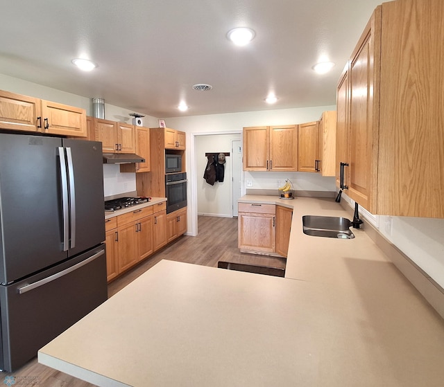 409 Prairieview St, St Thomas, ND 58276 - kitchen featuring light wood-style flooring, a sink, light countertops, under cabinet range hood, and black appliances
