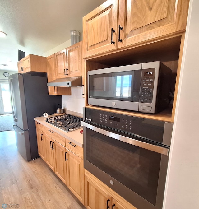 409 Prairieview St, St Thomas, ND 58276 - kitchen with light wood-type flooring, under cabinet range hood, stainless steel appliances, and light brown cabinets