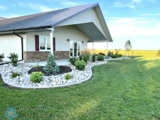 409 Prairieview St, St Thomas, ND 58276 - view of home's exterior featuring a lawn and metal roof