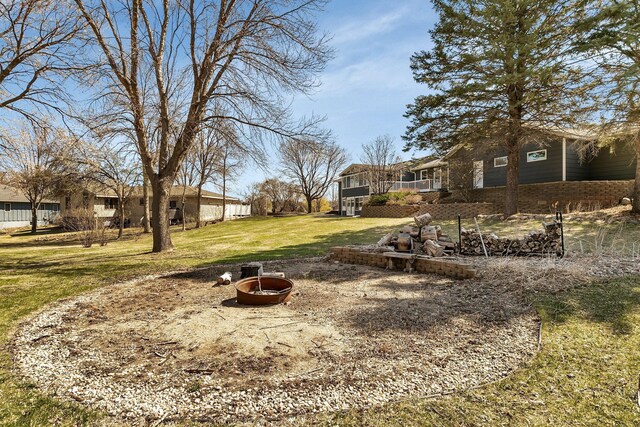 view of yard featuring a residential view, a wooden deck, and a fire pit