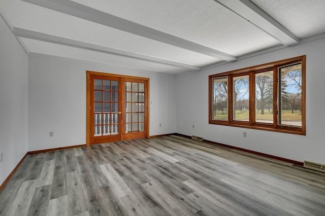 spare room with beamed ceiling, visible vents, french doors, and baseboards