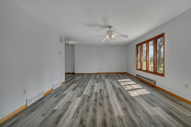 empty room with visible vents, baseboard heating, ceiling fan, and baseboards