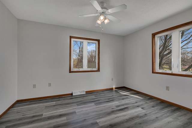 spare room with visible vents, wood finished floors, and plenty of natural light