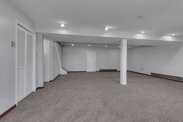 finished below grade area with stairs, carpet floors, a textured ceiling, and a baseboard radiator