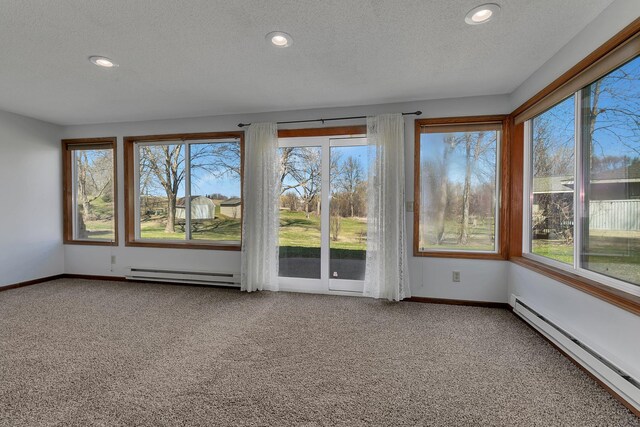 unfurnished sunroom with carpet, recessed lighting, and a baseboard heating unit