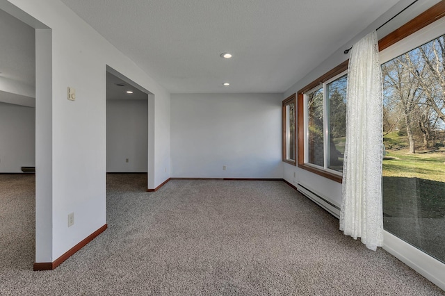 carpeted spare room featuring a baseboard heating unit, recessed lighting, and baseboards