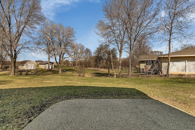 view of yard featuring an outdoor structure and a storage unit