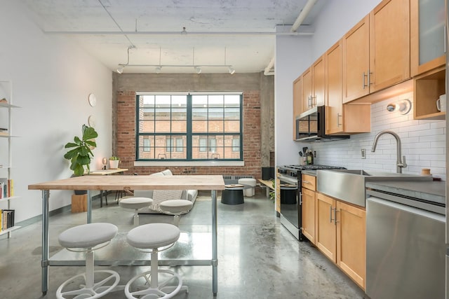 250 Park Ave Unit 601, Minneapolis, MN 55415 - kitchen with appliances with stainless steel finishes, finished concrete floors, decorative backsplash, light brown cabinets, and track lighting