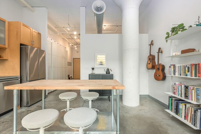 250 Park Ave Unit 601, Minneapolis, MN 55415 - kitchen featuring appliances with stainless steel finishes, concrete flooring, wooden counters, glass insert cabinets, and open shelves