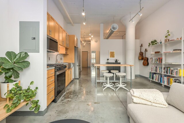 250 Park Ave Unit 601, Minneapolis, MN 55415 - kitchen with appliances with stainless steel finishes, rail lighting, electric panel, finished concrete floors, and tasteful backsplash