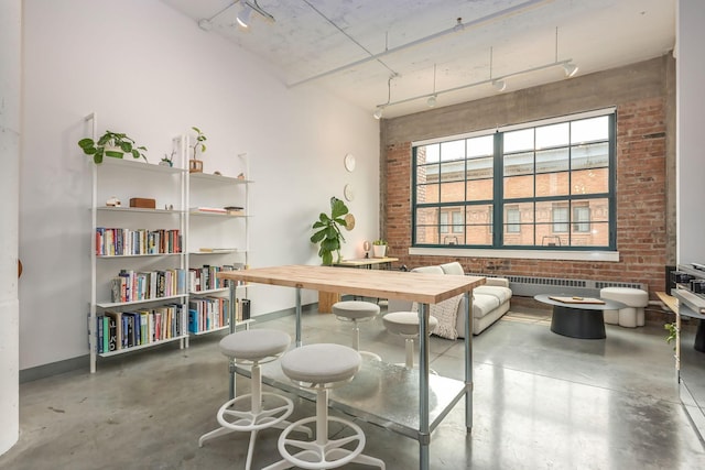 250 Park Ave Unit 601, Minneapolis, MN 55415 - dining space with concrete flooring, rail lighting, brick wall, radiator, and a high ceiling