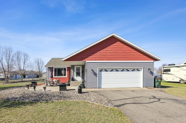 view of front of house with an attached garage, aphalt driveway, and a front lawn