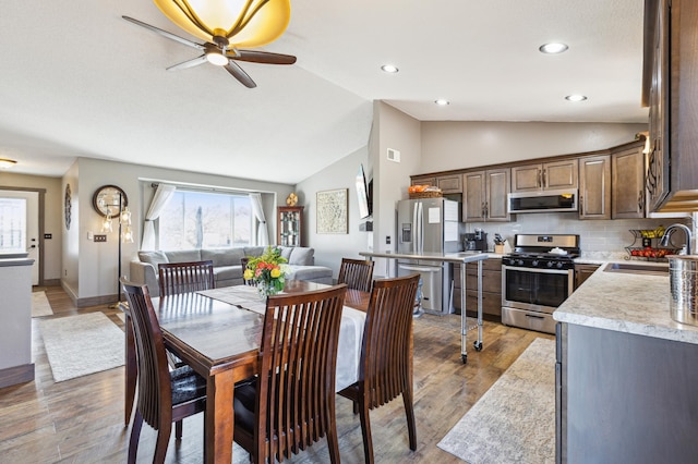 dining area with recessed lighting, a ceiling fan, vaulted ceiling, and wood finished floors