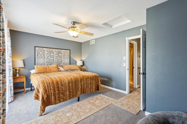 carpeted bedroom with attic access, visible vents, ceiling fan, and baseboards