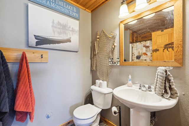 bathroom with curtained shower, toilet, a textured wall, and wooden ceiling
