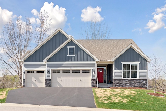 craftsman-style home featuring driveway, stone siding, board and batten siding, an attached garage, and a front yard