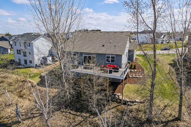 back of house featuring a residential view, roof with shingles, fence, and a deck