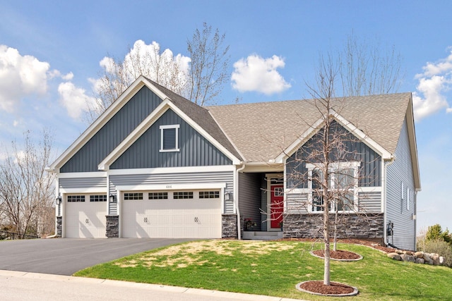 craftsman inspired home with an attached garage, stone siding, a front yard, and aphalt driveway