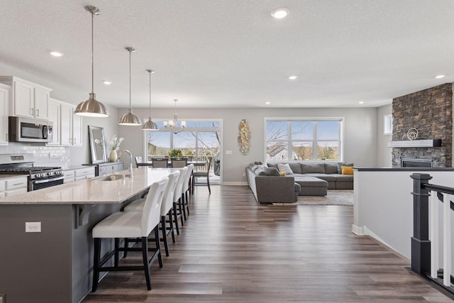 kitchen with white cabinets, recessed lighting, dark wood-style floors, a sink, and appliances with stainless steel finishes