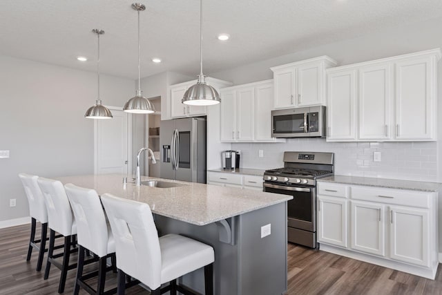 kitchen featuring decorative backsplash, a sink, an island with sink, and appliances with stainless steel finishes