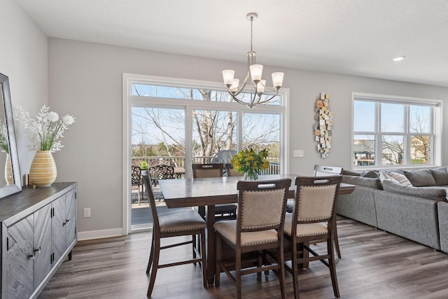 dining area featuring recessed lighting, an inviting chandelier, dark wood-style flooring, and a healthy amount of sunlight