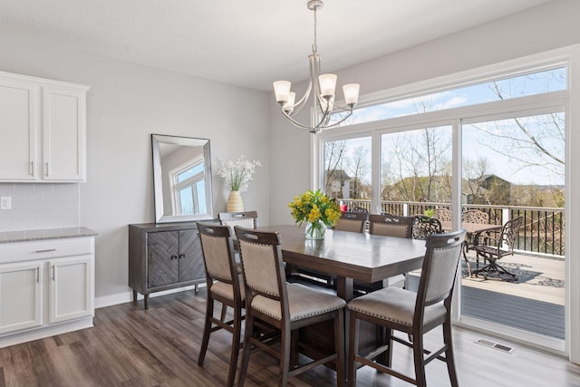dining area with dark wood-style flooring, a chandelier, and visible vents
