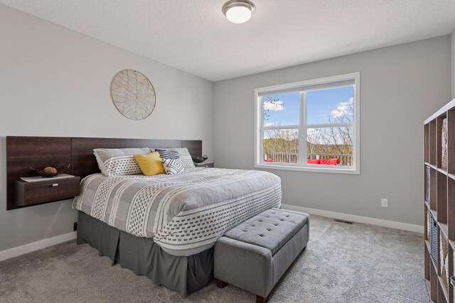 bedroom featuring visible vents, baseboards, carpet, and a textured ceiling