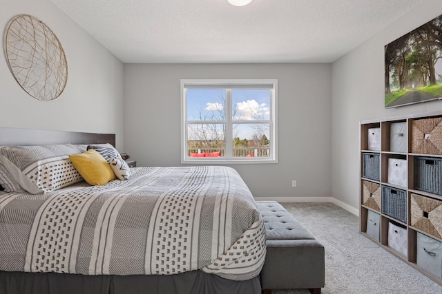 carpeted bedroom with baseboards and a textured ceiling