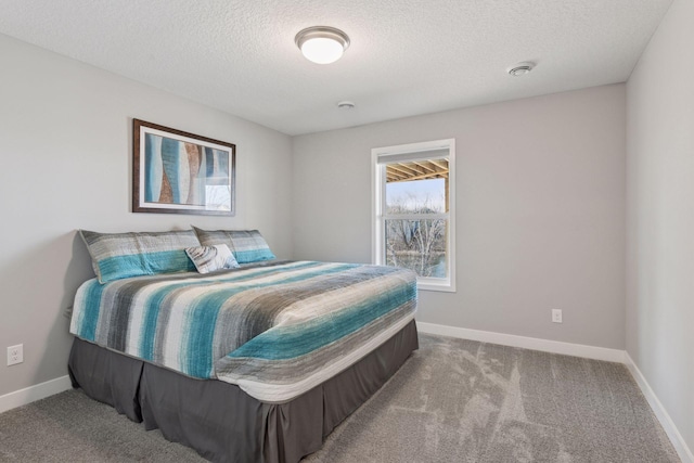 carpeted bedroom with baseboards and a textured ceiling