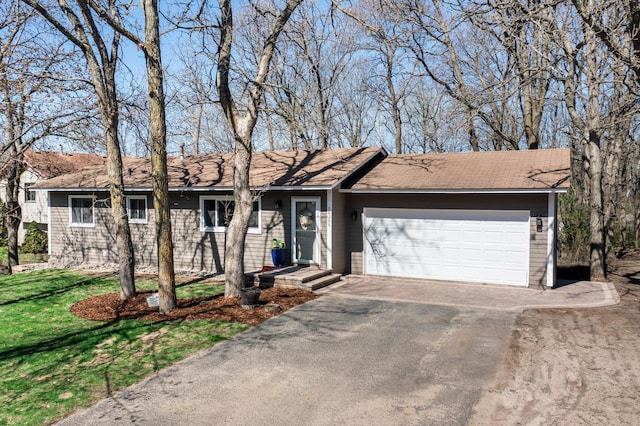 ranch-style home featuring a garage, a front lawn, and aphalt driveway
