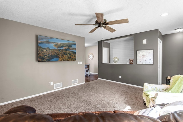 living area featuring carpet floors, a ceiling fan, baseboards, and visible vents