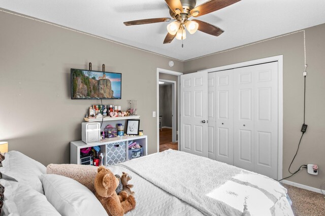 carpeted bedroom with baseboards, ceiling fan, and a closet